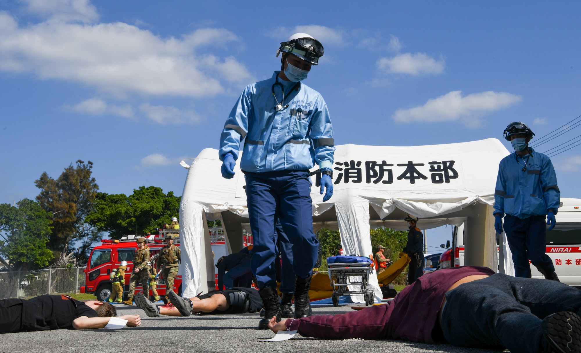 Okinawa emergency responders move simulated victims to a tent.