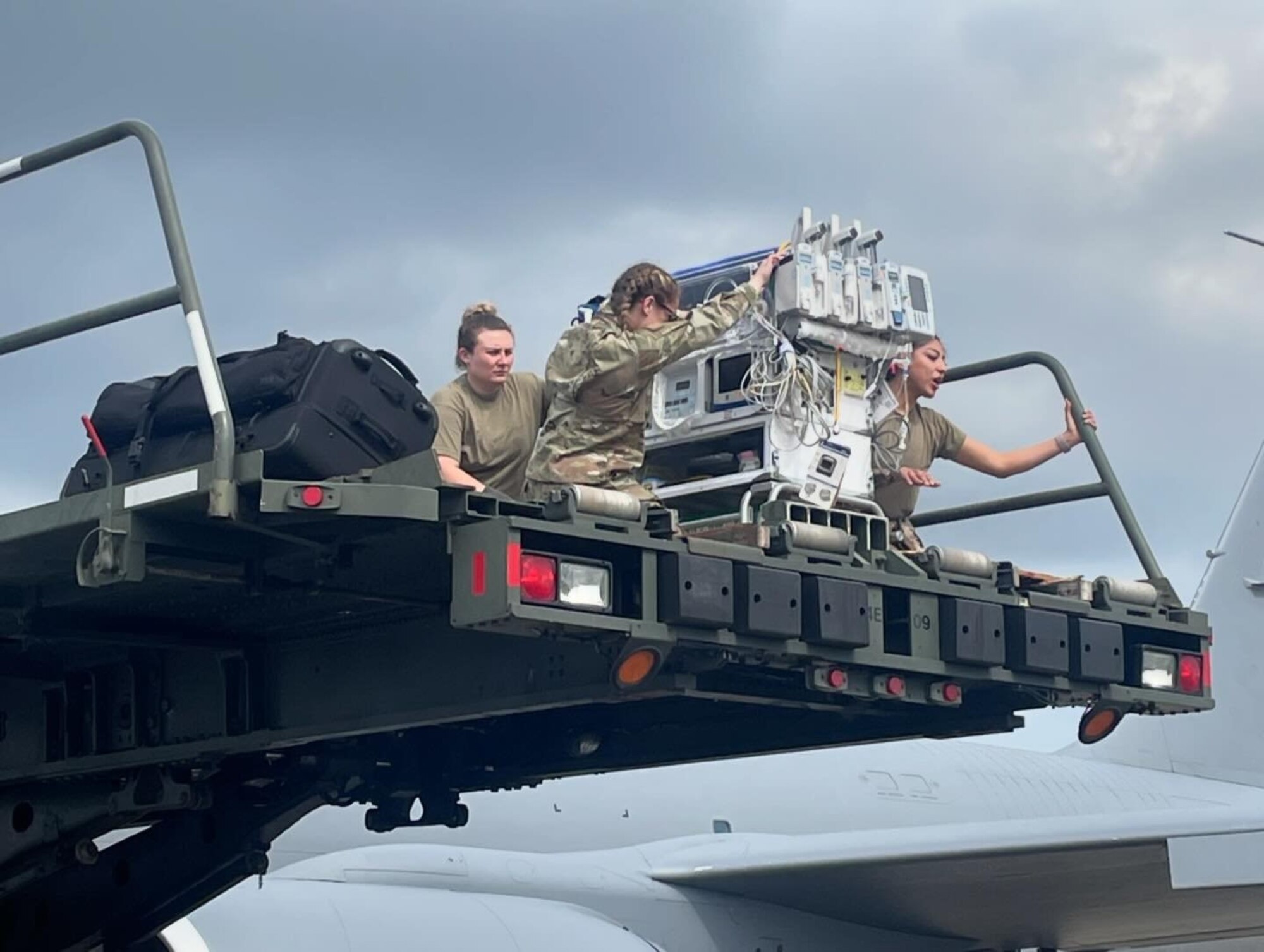 airmen sit on top of a transporter moving equipment