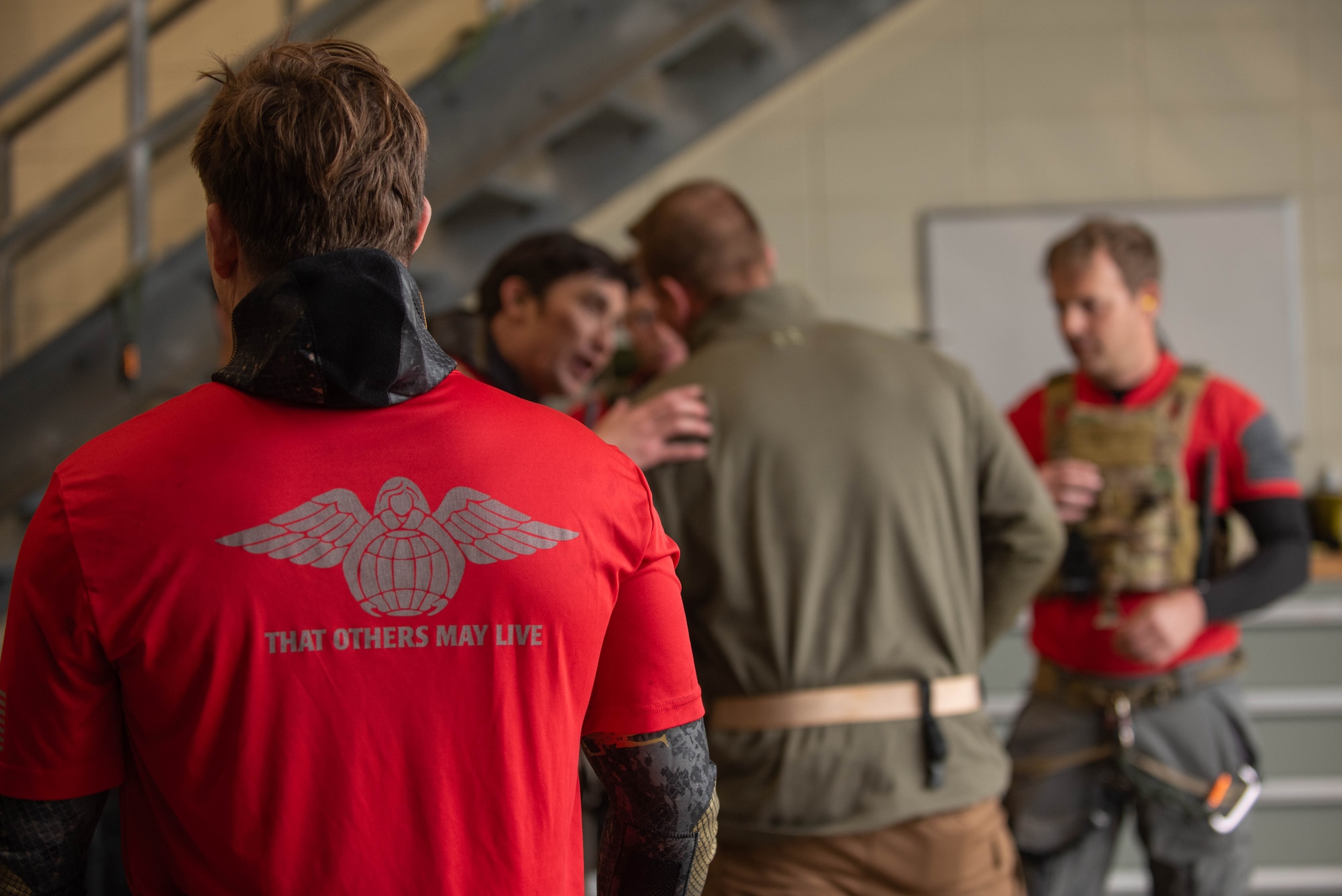 airmen and civilian get ready by putting on gear before a flight