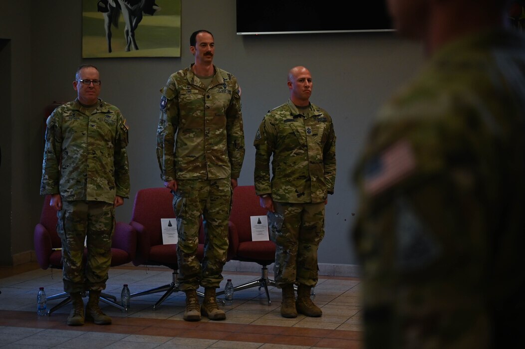 U.S. Space Force Col. Christopher Putman (left), U.S. Space Forces Central commander, Lt. Col. Deane Lake (center), incoming SPACECENT combat detachment 3-1 commander, and Senior Master Sgt. Boyette, SPACECENT senior enlisted leader, stand at attention during an activation and assumption of command ceremony at an undisclosed location within the U.S. Central Command area of responsibility, March 12, 2024.