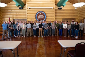 A group of men and women pose for a group photo.