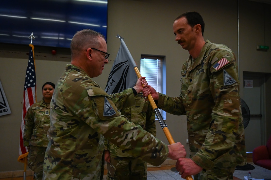 U.S. Space Force Col. Christopher Putman (left), U.S. Space Forces Central commander, passes on the guidon to Lt. Col. Deane Lake, SPACECENT combat detachment 3-1 commander, during an activation and assumption of command ceremony at an undisclosed location within the U.S. Central Command area of responsibility, March 12, 2024.
