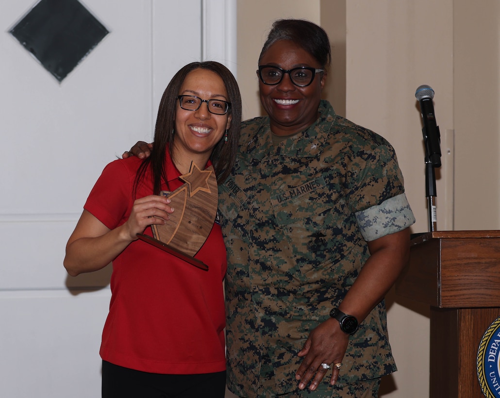 U.S. Marine Corps Col. Morina Foster, commanding officer of Wounded Warrior Regiment, presents an award to Yanira Holguin, a Semper Fit Dietician with the Marine Corps Community Services, during the Women’s Health Symposium 2024 at The Clubs at Quantico on Marine Corps Base Quantico, Virginia, March 18, 2024. The symposium covered a range of topics, concerning women’s health with the intent to educate and generate awareness to uniformed and civilian personnel. (U.S. Marine Corps photo by Lance Cpl. David Brandes)