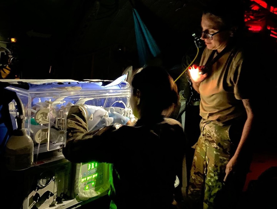 airmen take care of an infant inside of a plane