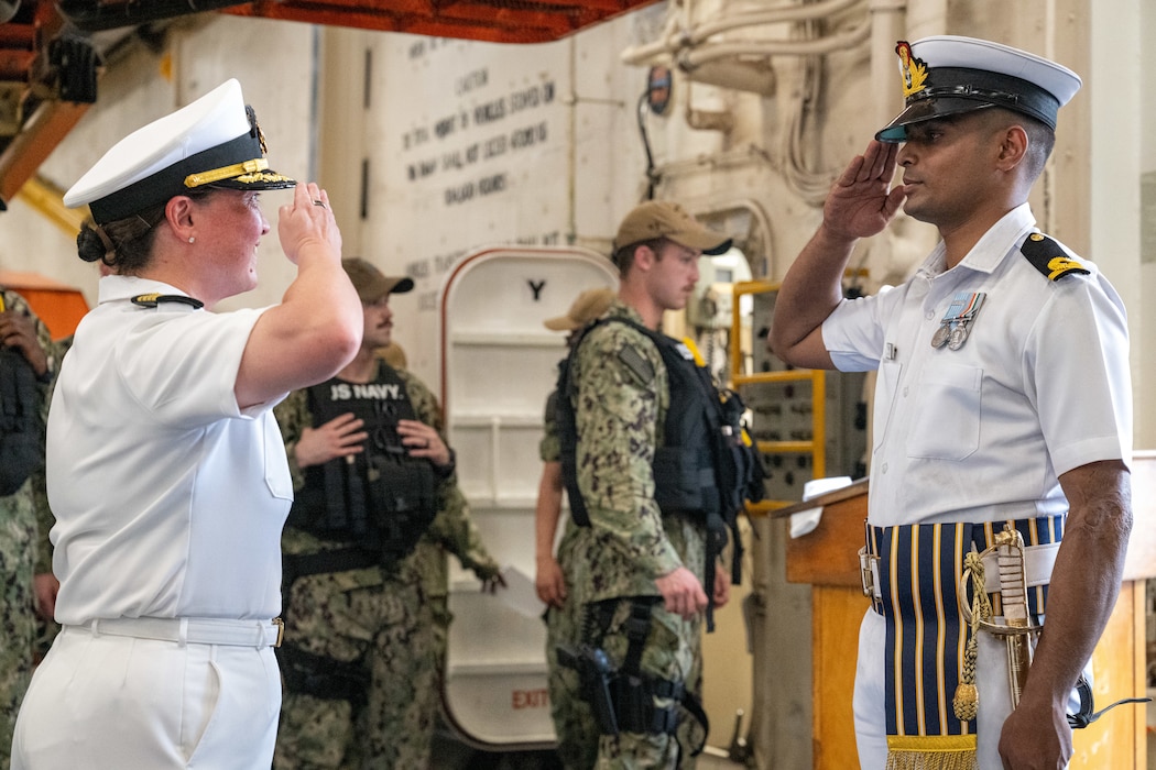 Capt. Michel Brandt, left, exchanges salutes with Indian navy Sub-Lieutenant Abhishek Mishra in Visakhapatnam, India.