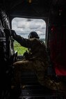 U.S. Army Staff Sgt. Patrick Smith, a flight engineer assigned to the 1st Squadron, 214th General Support Aviation Battalion, 12th Combat Aviation Brigade, looks out the window of a CH-47 Chinook helicopter in flight at Tampere, Finland, Aug. 4, 2022.