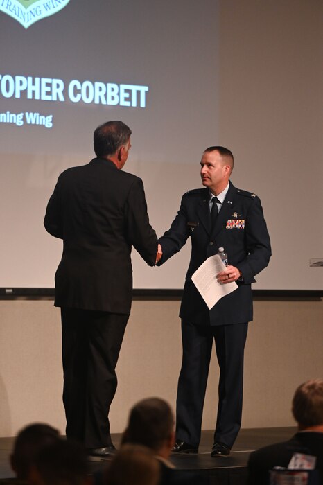 U.S. Air Force Col. Christopher Corbett, 17th Training Wing deputy commander, and Walt Koenig, San Angelo Chamber of Commerce president/CEO, shake hands during the San Angelo Chamber of Commerce State of Goodfellow luncheon at the McNease Convention Center, San Angelo, Texas, Mar. 19, 2024. Walt thanked Corbett for his speech and attendance at the event. (U.S. Air Force photo by Airman 1st Class Brian Lummus)