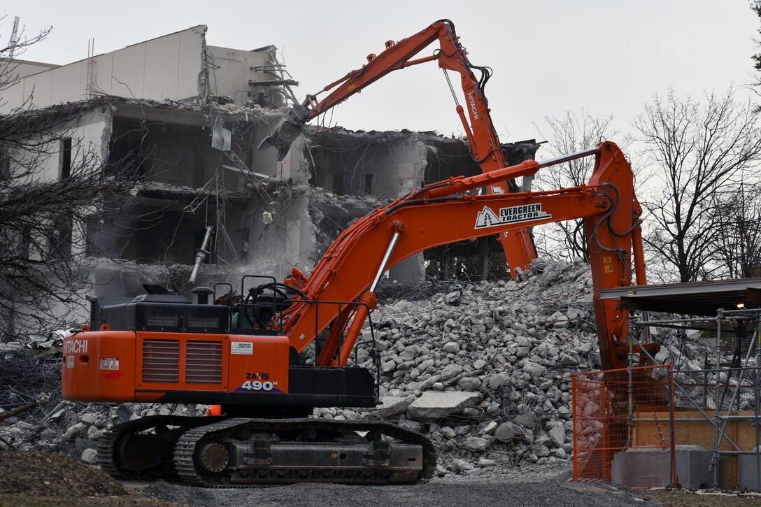Excavator clears debris from demolition
