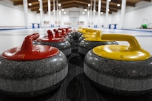 Curling stones are displayed at the Minot Curling Club, Minot, North Dakota, March 19, 2024. In the sport of curling, players score points by sliding these stones across a sheet of ice towards a designated target area. (U.S. Air Force photo by Airman 1st Class Kyle Wilson)