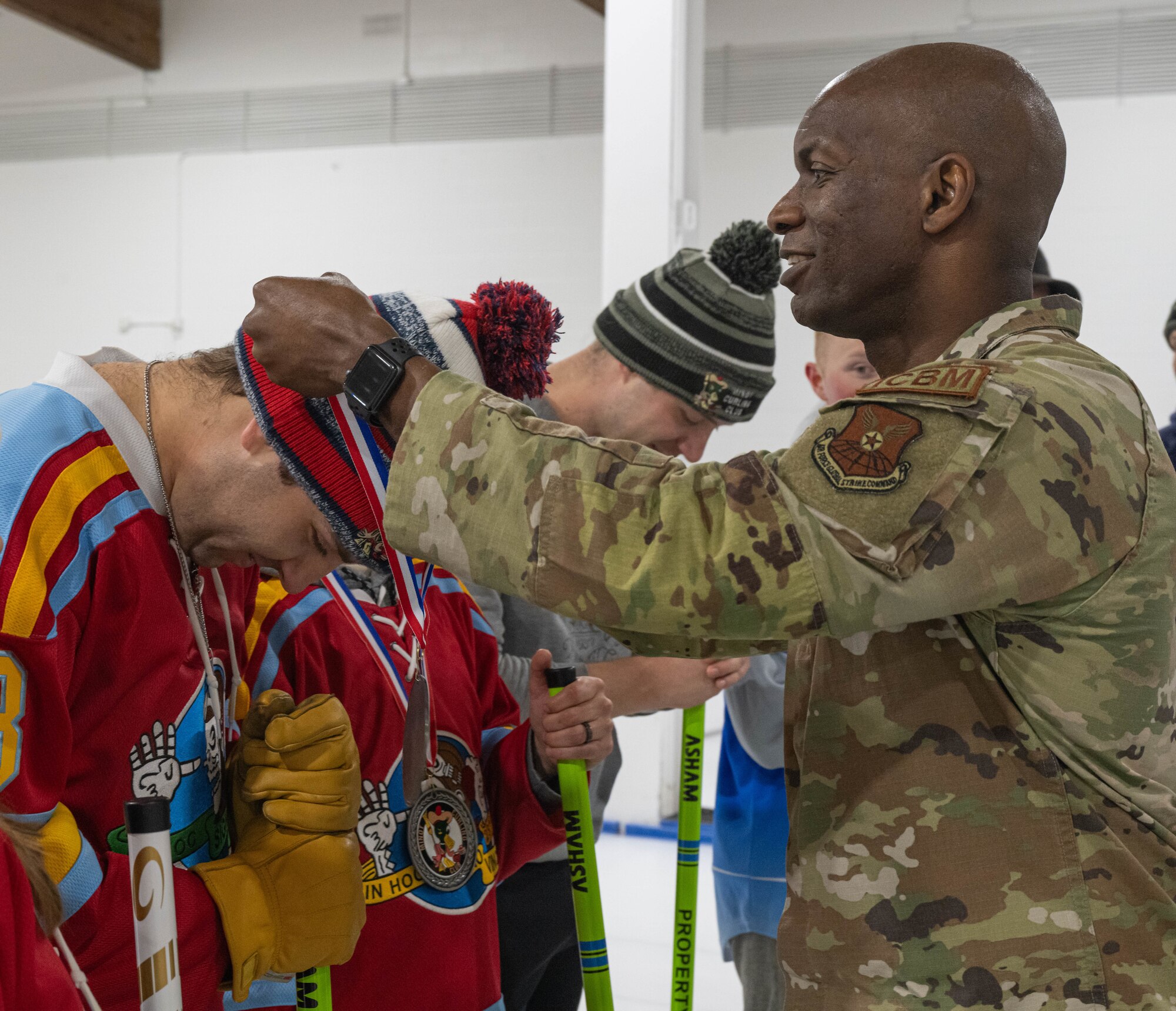 U.S. Air Force Col. Kenneth McGhee, 91st Missile Wing commander (right), presents medals to members of the Minot Air Force Base Curling League at the Minot Curling Club, Minot, North Dakota, March 19, 2024. McGhee attended the Minot AFB Curling League’s championship game and presented medals to the teams competing. (U.S. Air Force photo by Airman 1st Class Kyle Wilson)