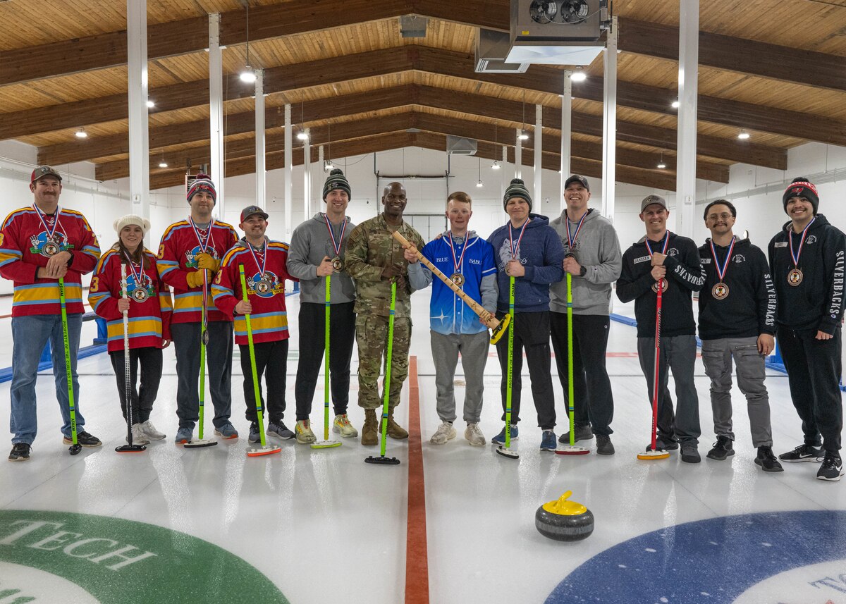 U.S. Air Force Col. Kenneth McGhee, 91st Missile Wing commander (center), and members of the Minot Air Force Base curling league pose for a photo at the Minot Curling Club, Minot, North Dakota, March 19, 2024. McGhee attended the Minot AFB Curling League’s championship game and presented medals to the teams competing. (U.S. Air Force photo by Airman 1st Class Kyle Wilson)