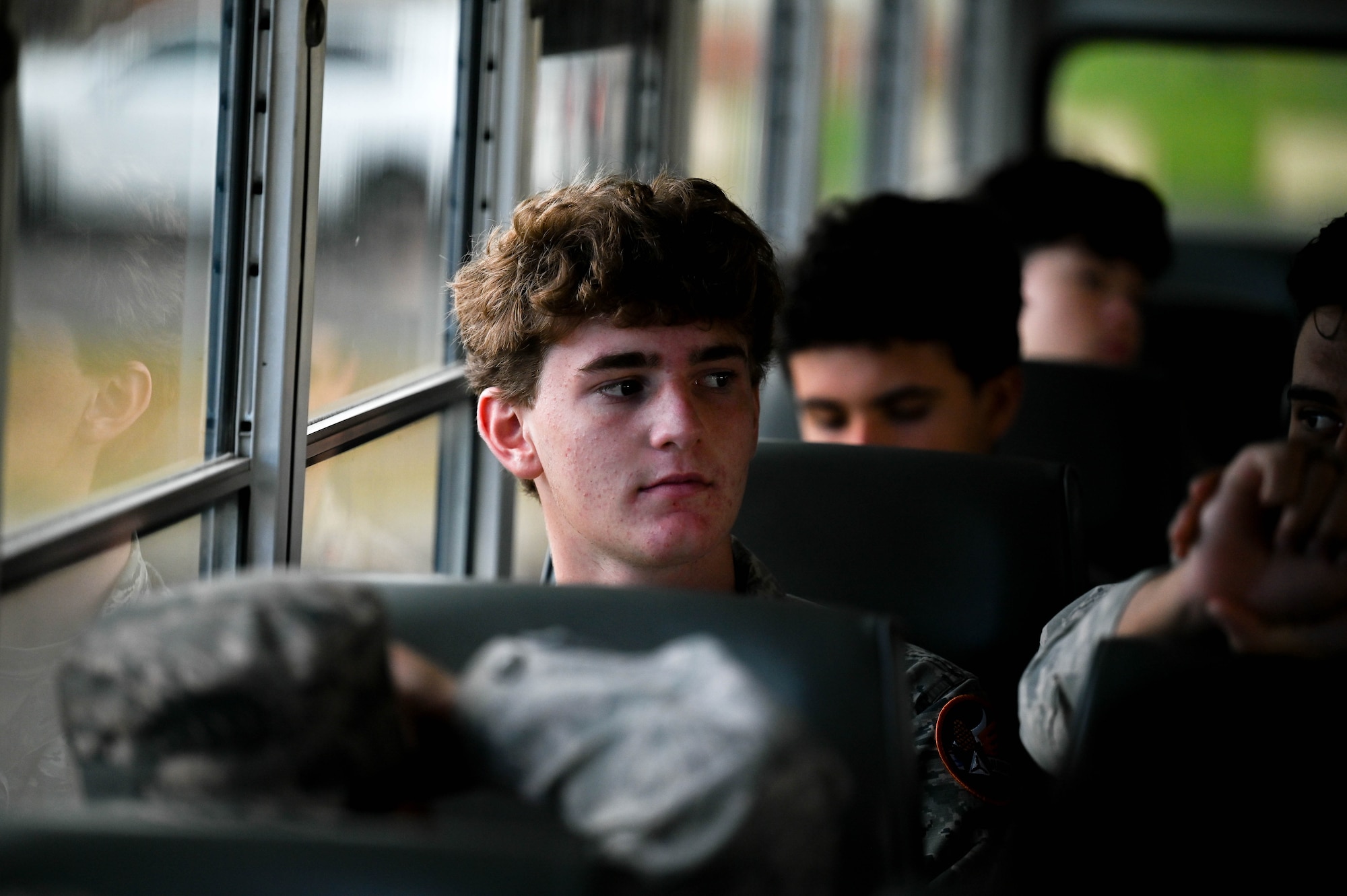 Kid sits on a bus heading towards a flight.