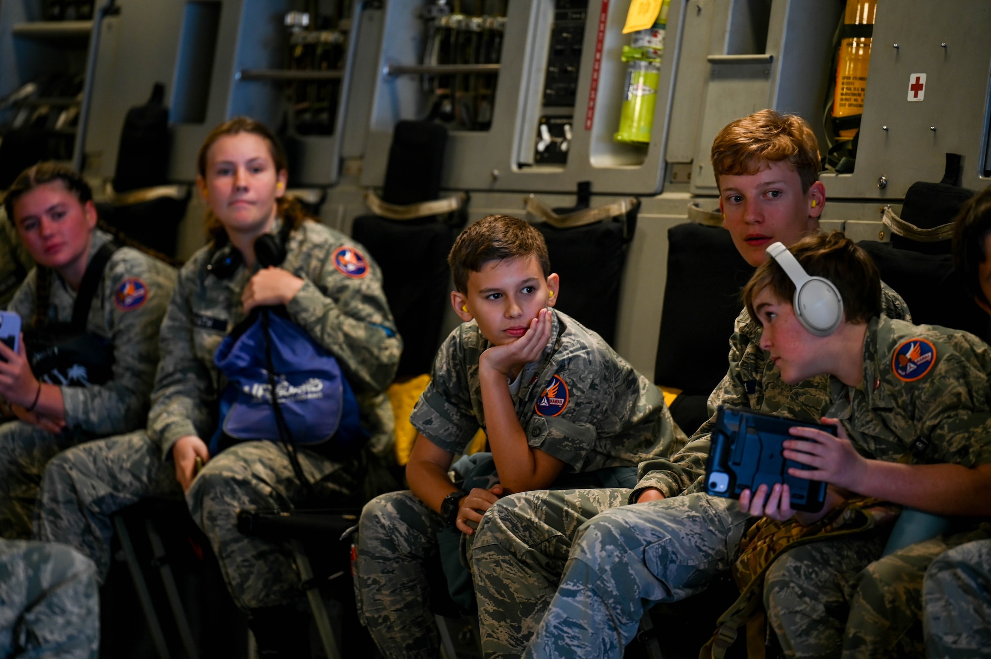 Kids sitting inside an aircraft looking around.