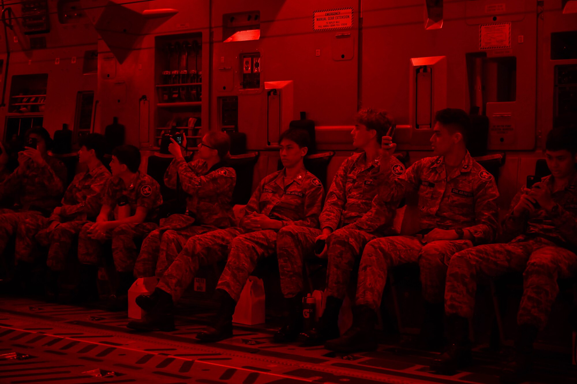Kids sit during a flight with red lights on.
