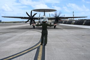 An Airman and a Sailor work on pulling back the refueling equipment.