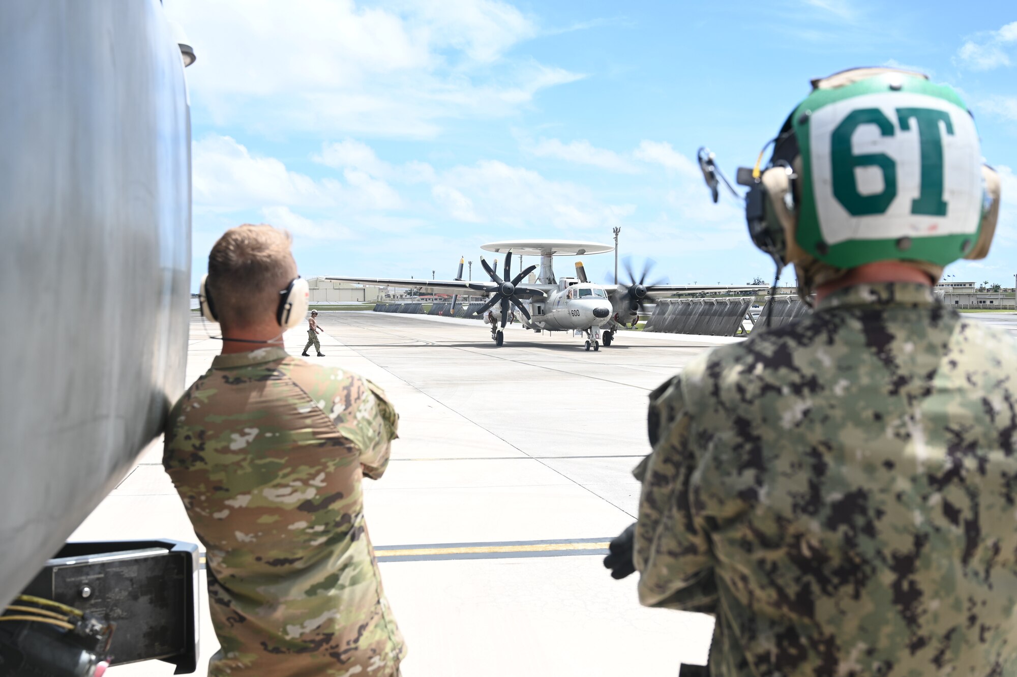 An Airman and a Sailor prepares to refuel an E-2D Hawkeye aircraft.
