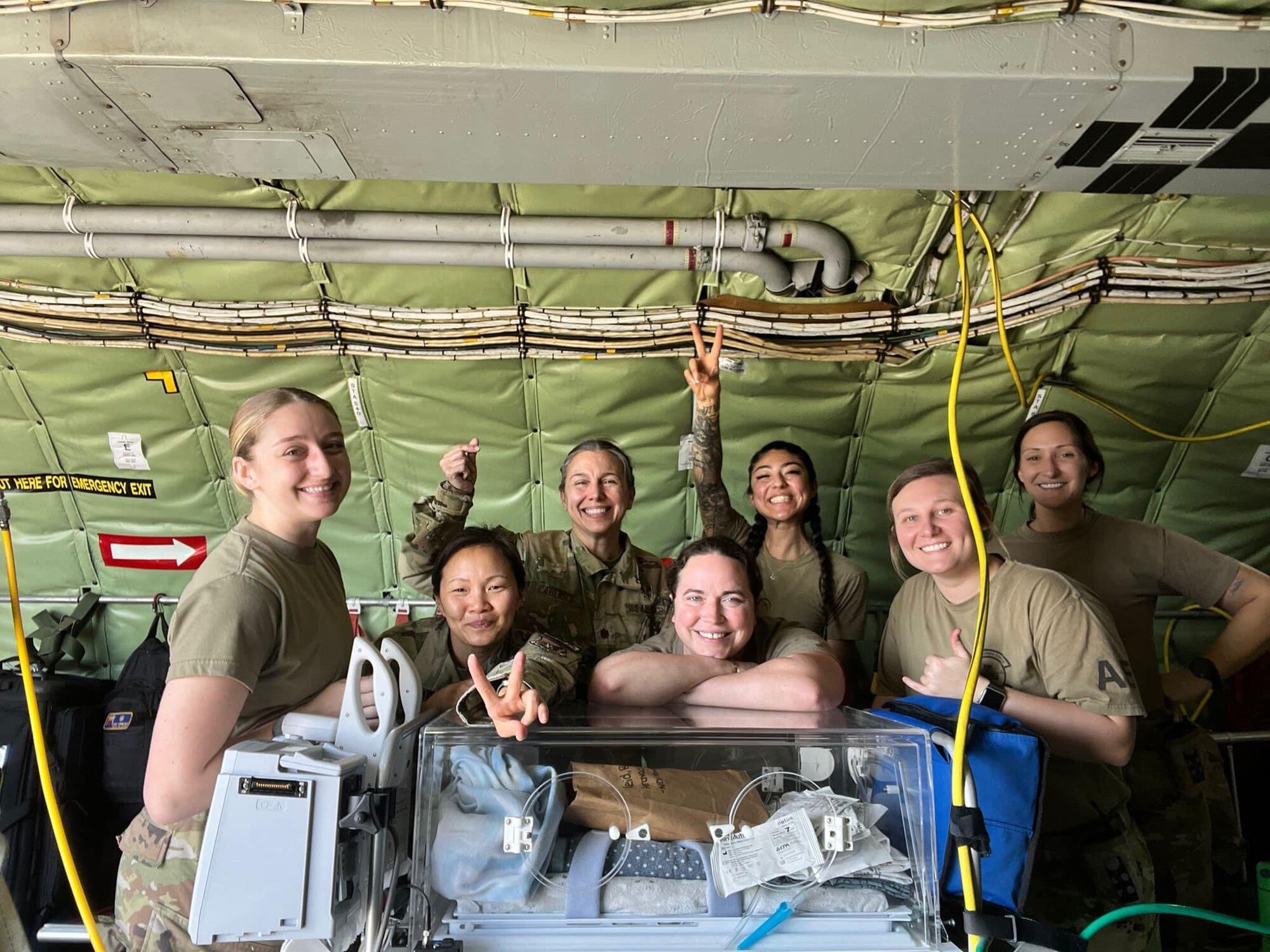 nurses pose for a photo inside of a plane