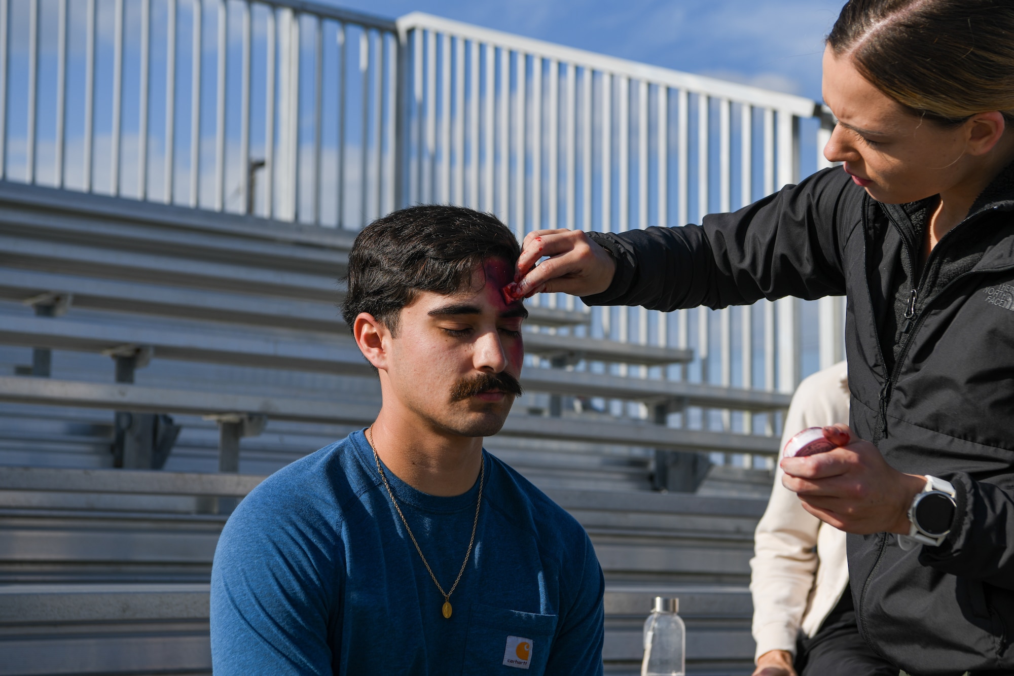 U.S. Air Force Staff Sgt. April Vanhorn, 18th Operational Medical Squadron aeromedical evacuation technician, applies moulage to U.S. Air Force Senior Airman Phoenix Fabila, 18th Civil Engineer Squadron  structural journeyman.