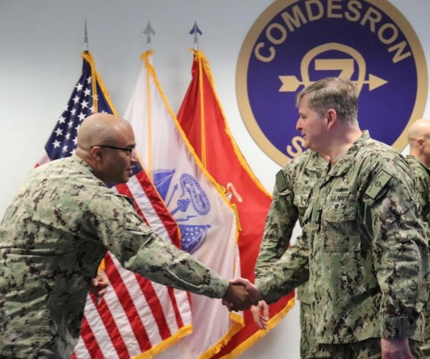 SINGAPORE (March 22, 2024) - Vice Adm. Fred Kacher, right, Commander, U.S. 7th Fleet is greeted by Chief Operations Specialist Jeremy Harris during a visit to Commander, Destroyer Squadron (DESRON) 7 , March 22. As the U.S. Navy’s destroyer squadron forward-deployed in Southeast Asia, DESRON 7 serves as the primary tactical and operational commander of littoral combat ships rotationally deployed to Singapore, Expeditionary Strike Group 7’s Sea Combat Commander and builds partnerships through training exercises and military-to-military engagements. (U.S. Navy photo by Lt. j.g. Rebecca Moore)