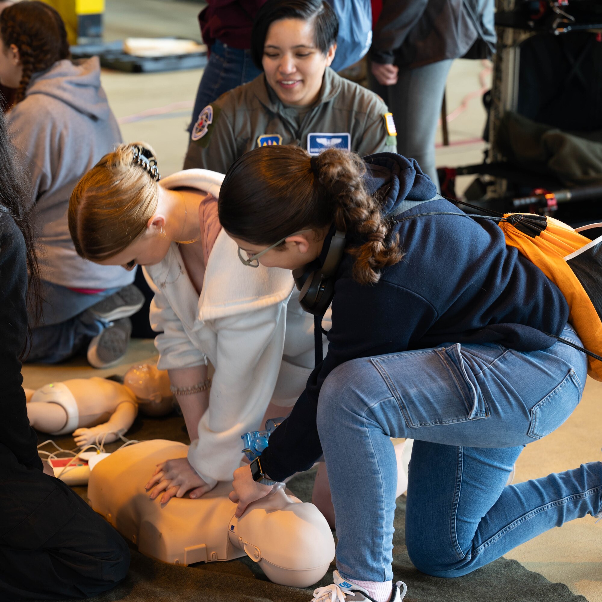 Department of Defense Education Activity students practice CPR during a Fly Like a Girl event at Ramstein Air Base, Germany, March 20, 2024.