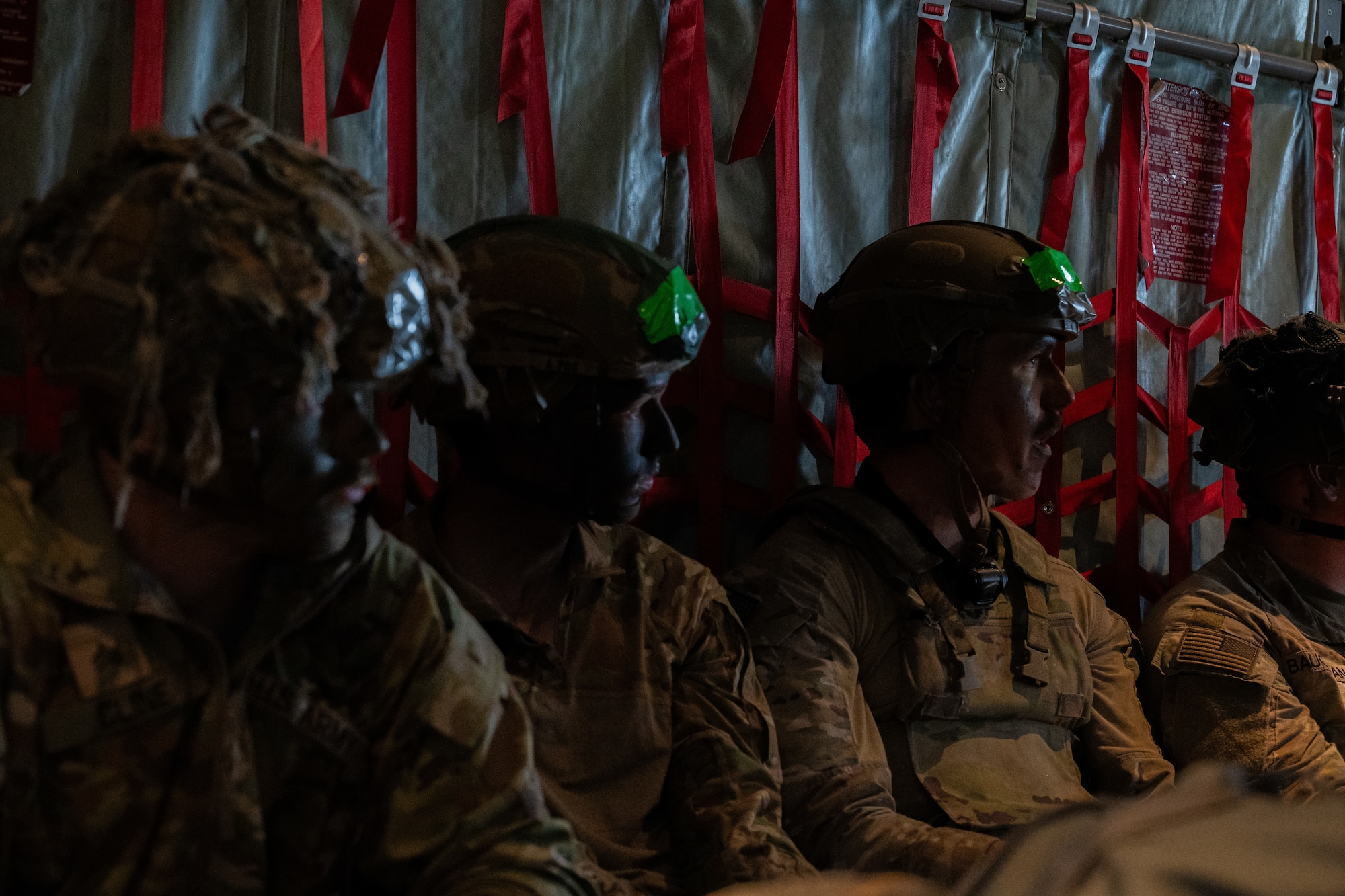 Soldiers sit in the back of a C-130J