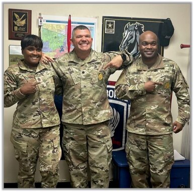 An Army Lt. Col., Command Sgt. Maj. and Sgt. Maj. pose pointing to their recruiting gold badge on their uniform.