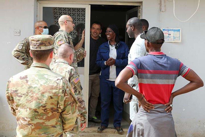 Service members meet with Senegal residents at a hospital.