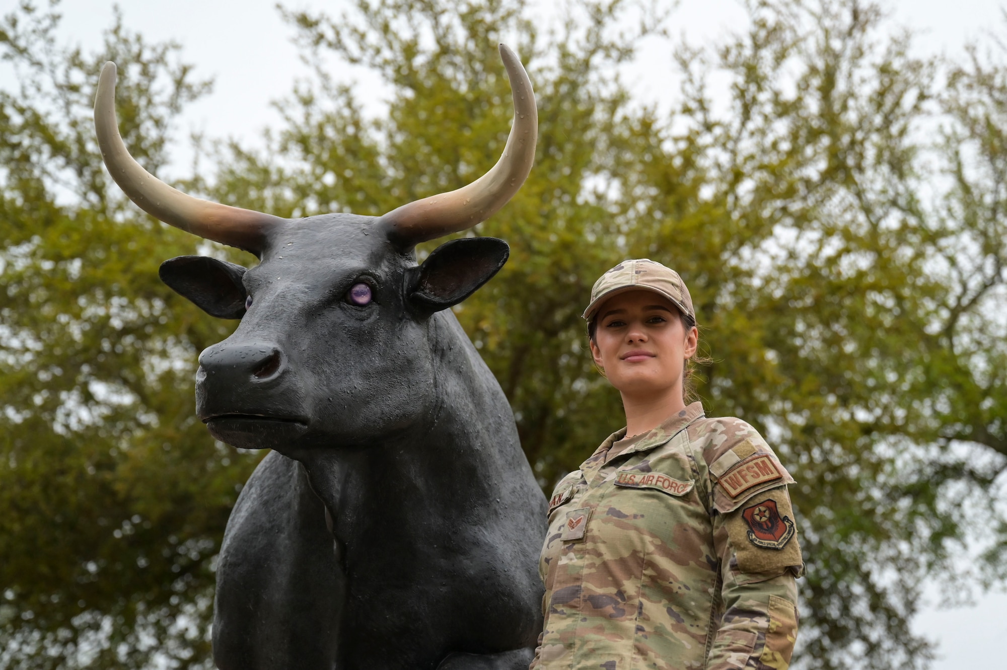 U.S. Air Force Senior Airman Collby Moran, a 1st Special Operations Civil Engineer Squadron water and fuel systems maintenance journeyman, poses for a portrait photo next to the 1 SOCES bull statue at Hurlburt Field, Florida, March 26, 2024.