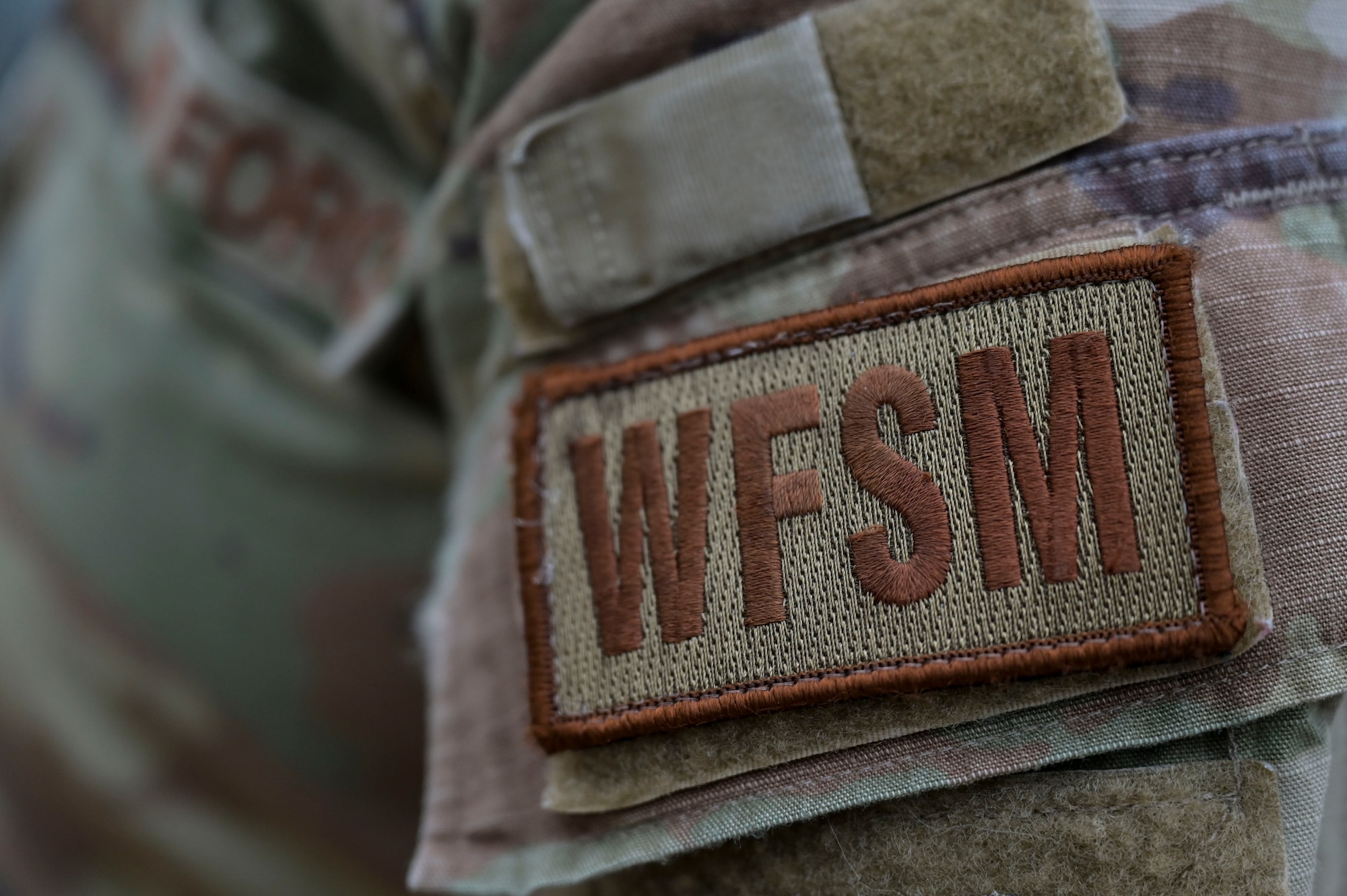 U.S. Air Force Senior Airman Collby Moran, a 1st Special Operations Civil Engineer Squadron water and fuels systems maintenance journeyman, poses for a photo of the water and fuel systems maintenance patch at Hurlburt Field, Florida, March 26, 2024.