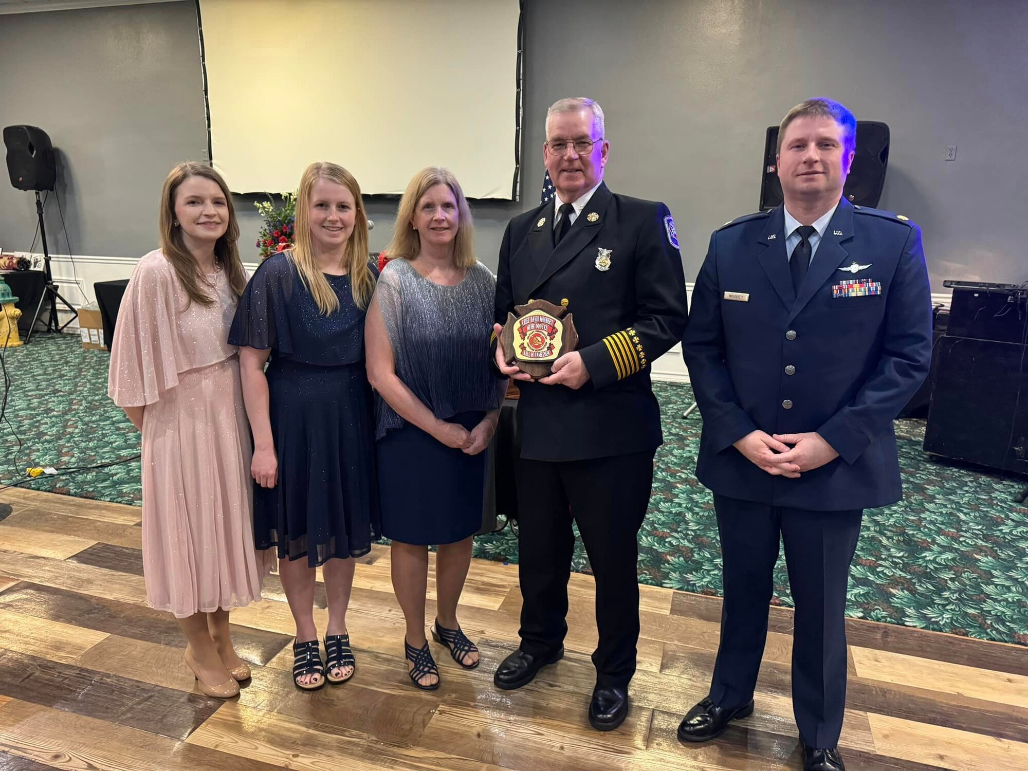 Two firefighters stand with their family.