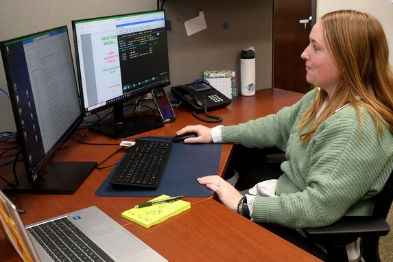 Whitney Hartwell, Redstone Arsenal Army Military Pay Office military pay technician, who is married to U.S. Army Capt. Joshua Hartwell, assistant project manager for acquisitions at the Army Program Executive Office Missiles and Space, poses for a photo in the AMPO at Redstone Arsenal, Alabama, March 26, 2024. A recent U.S. Army Financial Management Command initiative ensures AMPO employees who relocate with their service member spouses during permanent changes of station will maintain their positions within the command. (U.S. Army photo by Eric Schultz)