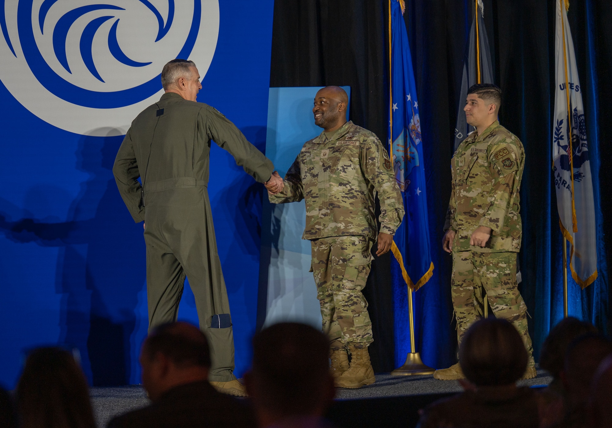 Gen. Mike Minihan, Commander of Air Mobility Command, presents MSgt Elrico Edwards from the 512 Airlift Wing with an Air Medal with Combat Device and SSgt Vincent Brooks from the 305 Maintenance Squadron with an Air Medal with Valor Device at the 2024 Logistics Officers Association Symposium. (U.S. Air Force photo by Air Mobility Command Public Affairs)