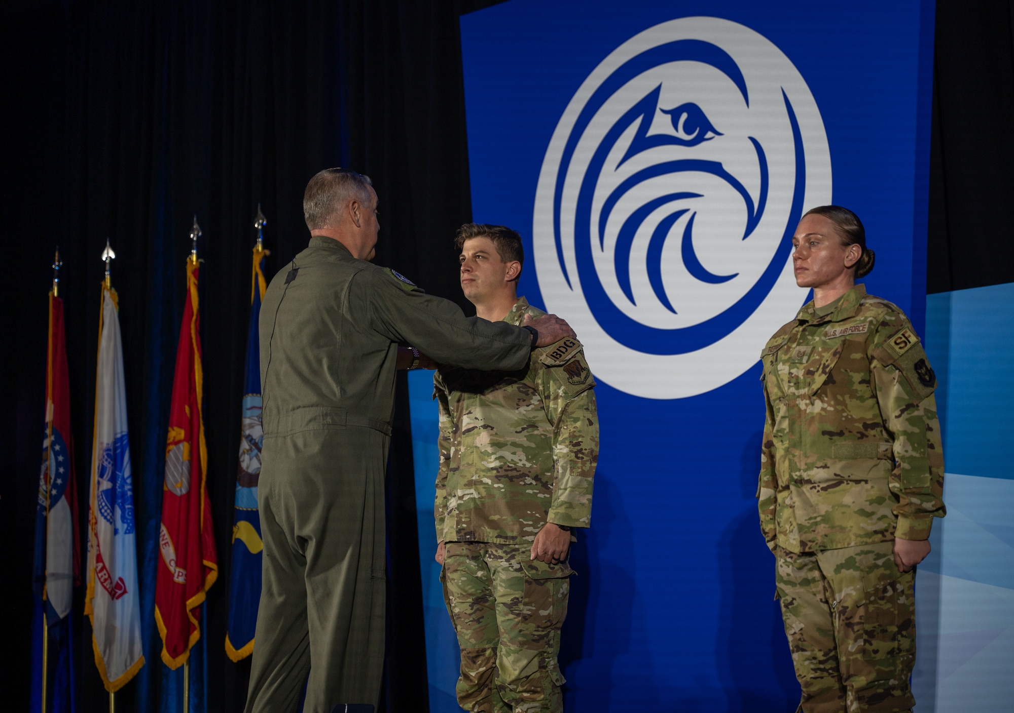 Gen. Mike Minihan, Commander of Air Mobility Command, presents TSgt Joshua Cramer from the 822 Base Defense Squadron and TSgt Tara Repose from the 514 Security Forces Squadron with Distinguished Flying Crosses with Combat Devices at the 2024 Logistics Officers Association Symposium. (U.S. Air Force photo by Air Mobility Command Public Affairs)