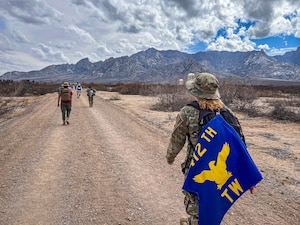 Staff Sgt. Wendy Updegrave, Flight and Operational Medicine Clinic noncommissioned officer-in-charge, 412th Operational Medical Readiness Squadron, shows off the 412th Test Wing guidon and a photo of her grandfather, which she carried with her during the Bataan Memorial Death March at White Sands Missile Range, New Mexico, March. 16. (Photo courtesy of Staff Sgt. Wendy Updegrave)
