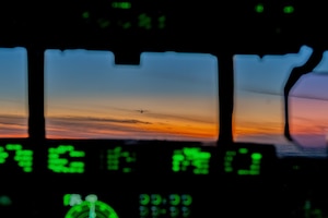 A C-130J flies during sunset