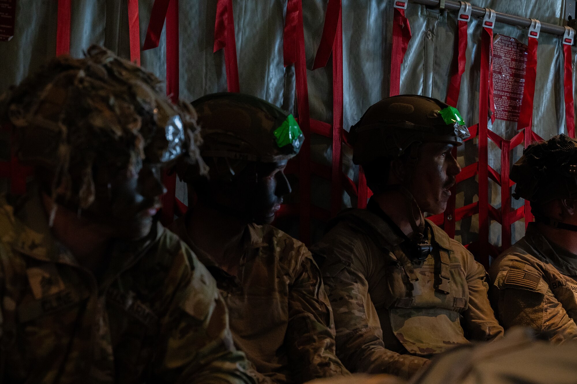 Soldiers sit in the back of a C-130J
