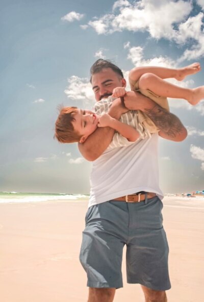 U.S. Air Force Senior Airman Andy Soto, a 1st Special Operations Force Support Squadron fitness specialist, plays with his son at Grayton Beach. Soto has utilized base resources such as the Child Development Center and Family Care Program to help him balance being a single father and an Airman. (Courtesy photo)