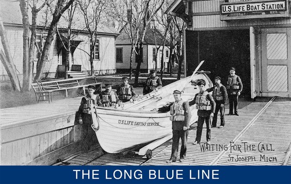 A photograph of the U.S. Life Saving Service crew posing with its surfboat in front of U.S. Life-Saving Station at St. Joseph, Michigan, from the Digital Collections of the Detroit Public Library.