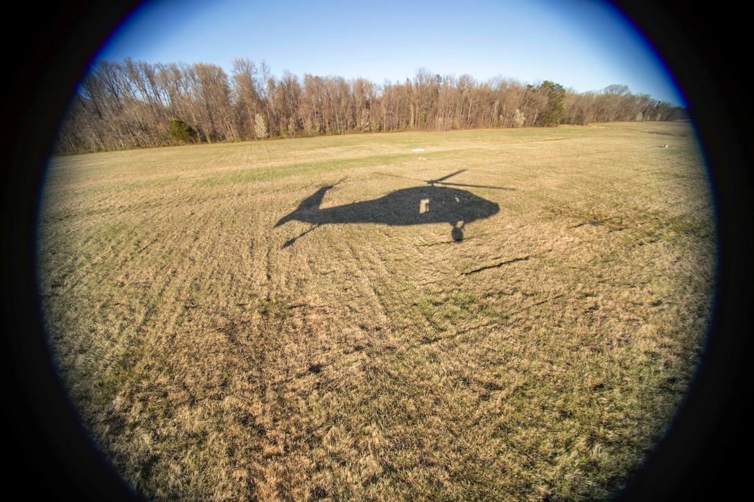 The shadow of a helicopter is seen from the helicopter’s window.