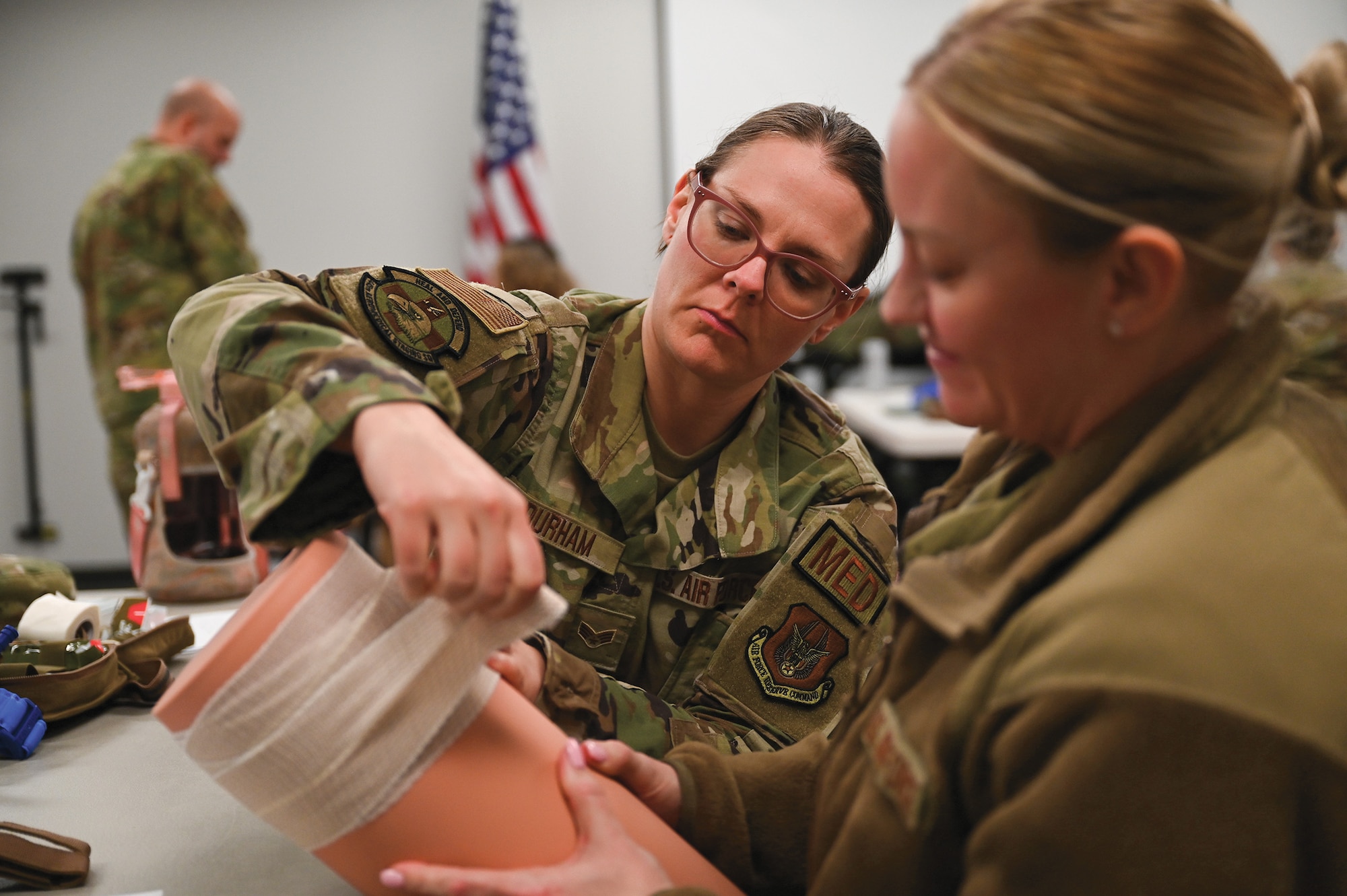 Senior Airman Sarah Durham, 445th Aeromedical Staging Squadron medical technician, applies a pressure dressing on a training mannequin while Master Sgt. Amanda Crider, 445th Aerospace Medicine Squadron flight and operational medical technician, applies pressure during Tactical Combat Casualty Care training at Wright-Patterson Air Force Base, Ohio, March 11, 2024. (U.S. Air Force photo/Mr. Patrick OReilly)