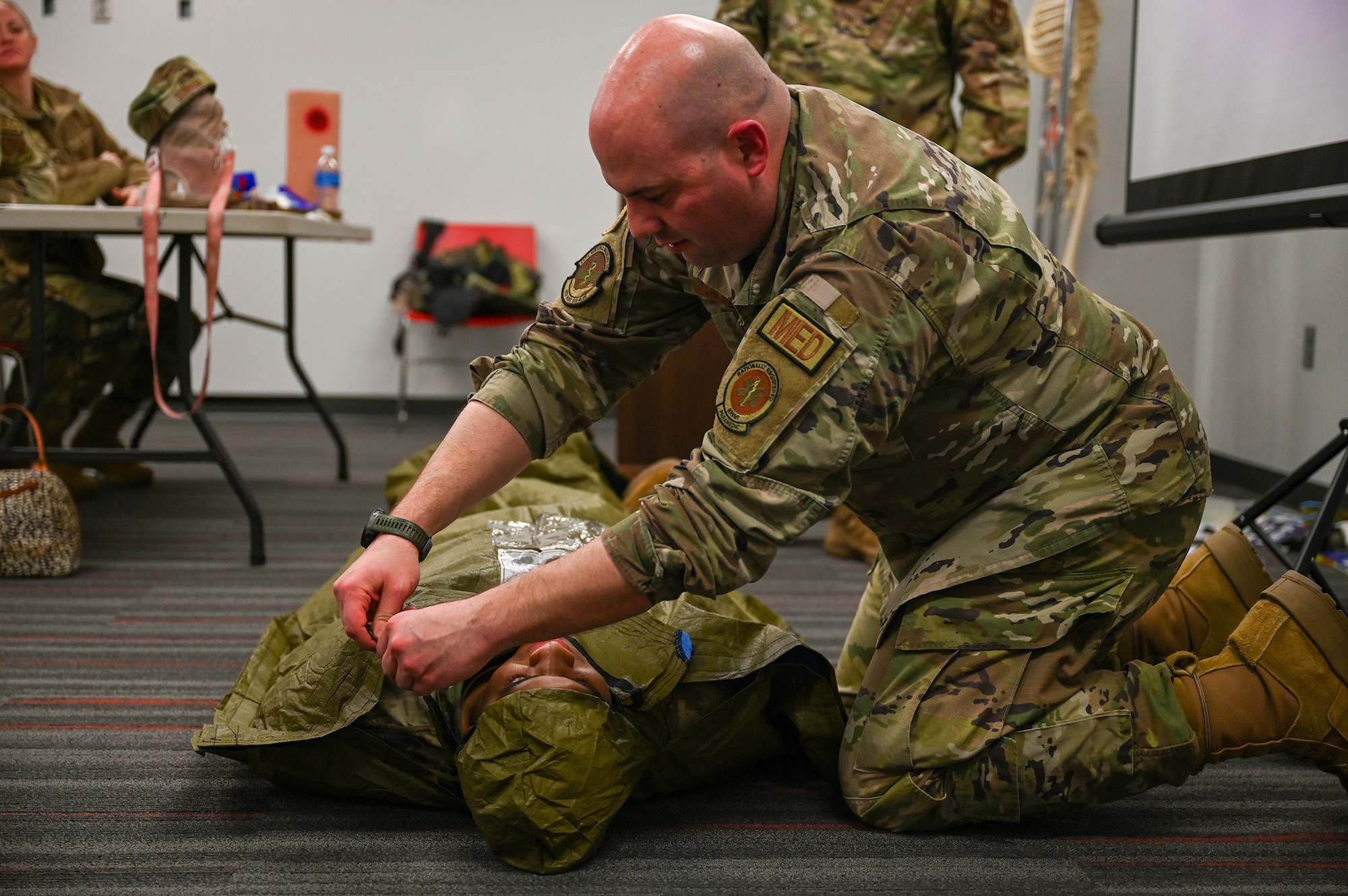 Tech. Sgt. Anthony Marrazzi, 445th Aerospace Medicine Squadron flight and operational medical technician, covers Staff Sgt. Jamal Chandler, 445th AMDS optometry technician, to demonstrate tactical field care for hyperthermia at Wright-Patterson AFB, Ohio, March 11, 2024.
