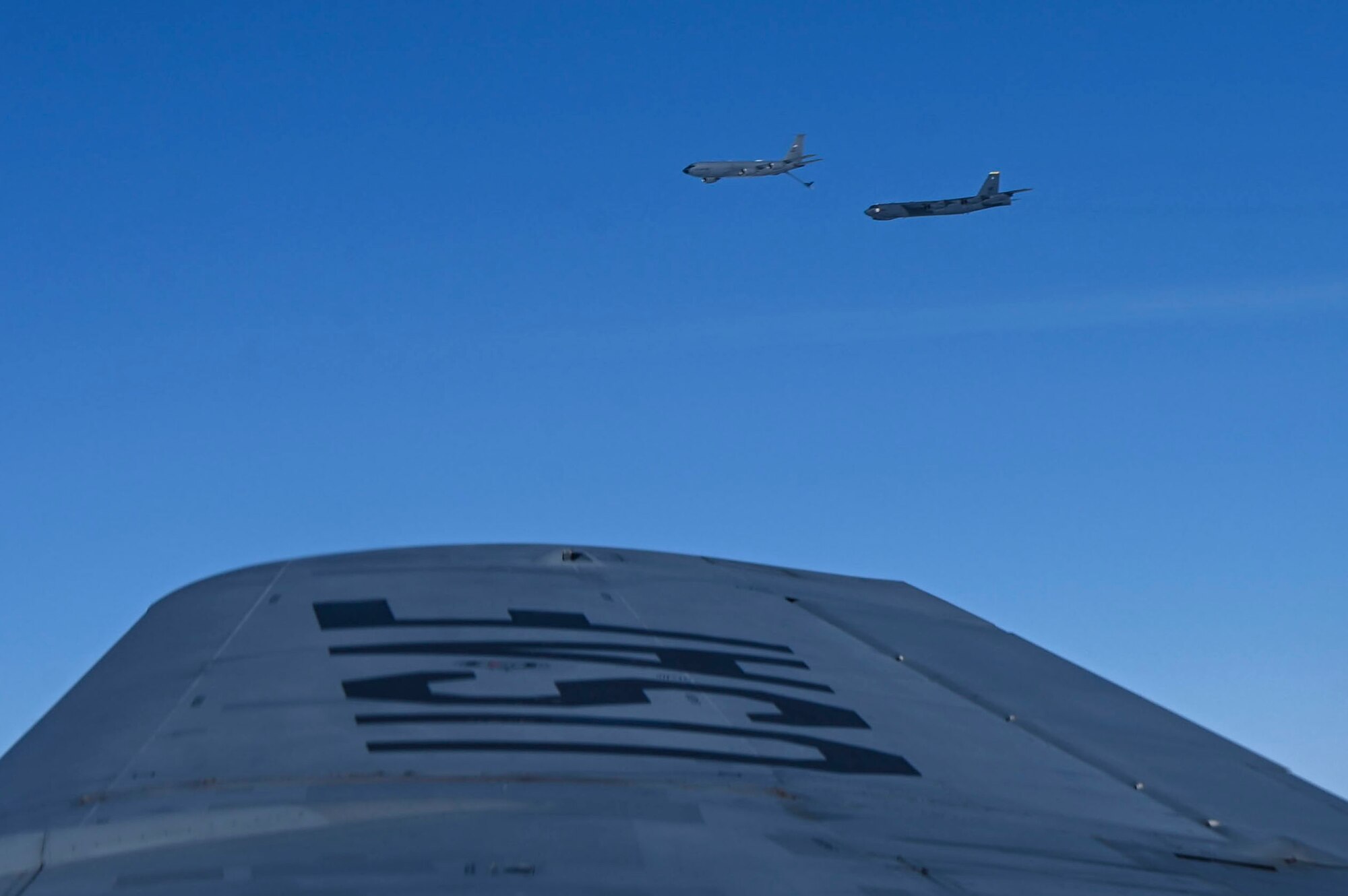 A B-52 Stratofortress flies up to a KC-135 Stratotanker to receive fuel.