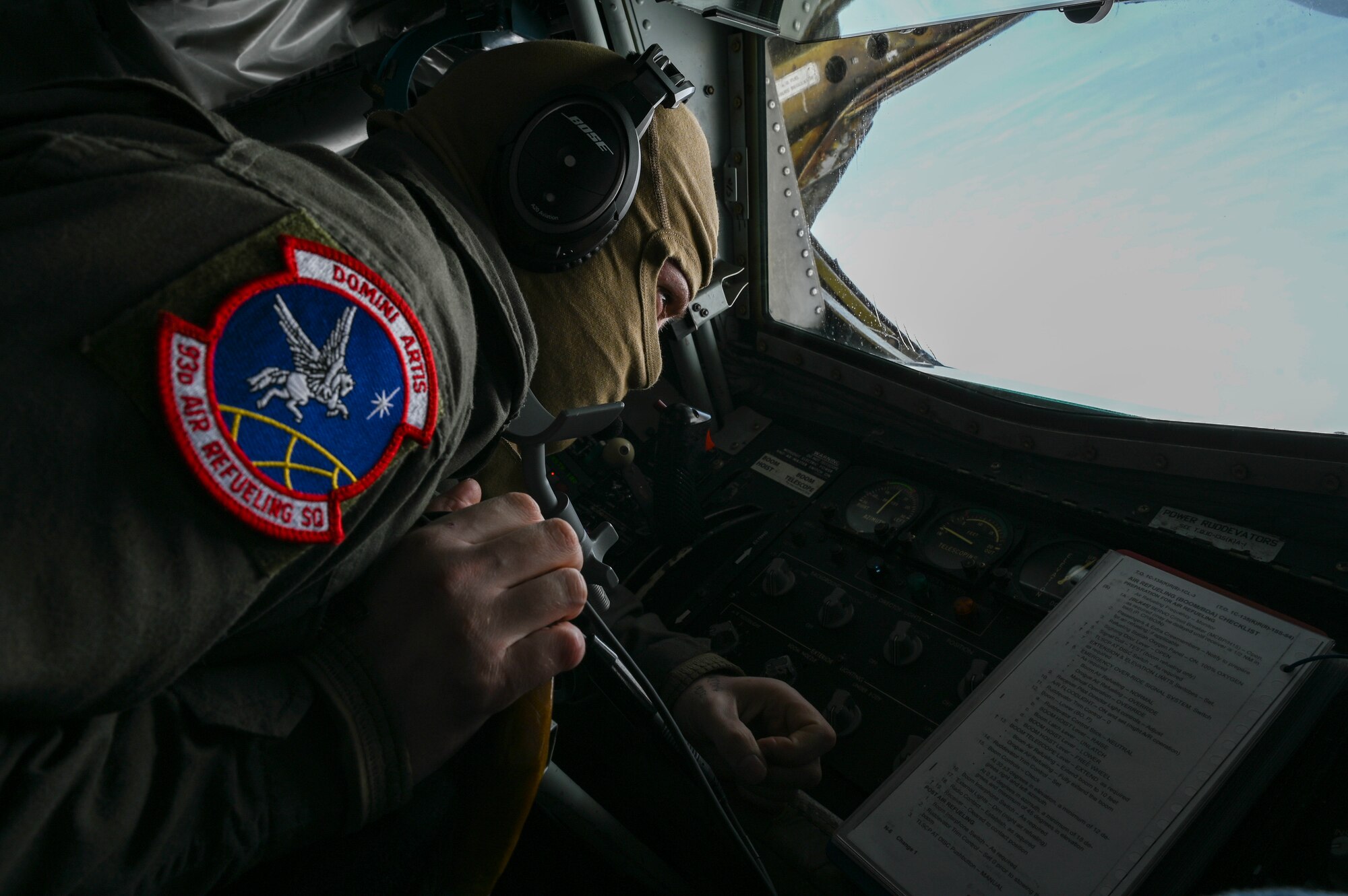 A boom operator looks out the window of a boom pod.
