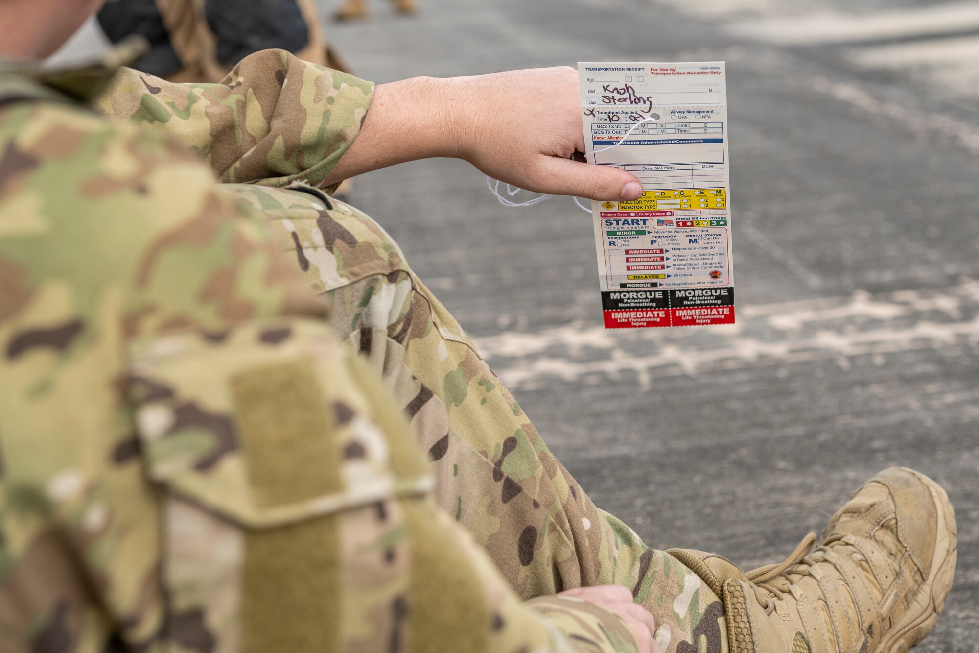 U.S. Air Force Senior Airman Cash Stirling, 41st Rescue Squadron special missions aviator, holds a triage tag during an aircraft accident response exercise at Moody Air Force Base, Georgia, March 26, 2024. These tags alert medical professionals of an individual’s injury condition. (U.S. Air Force photo by Senior Airman Deanna Muir)