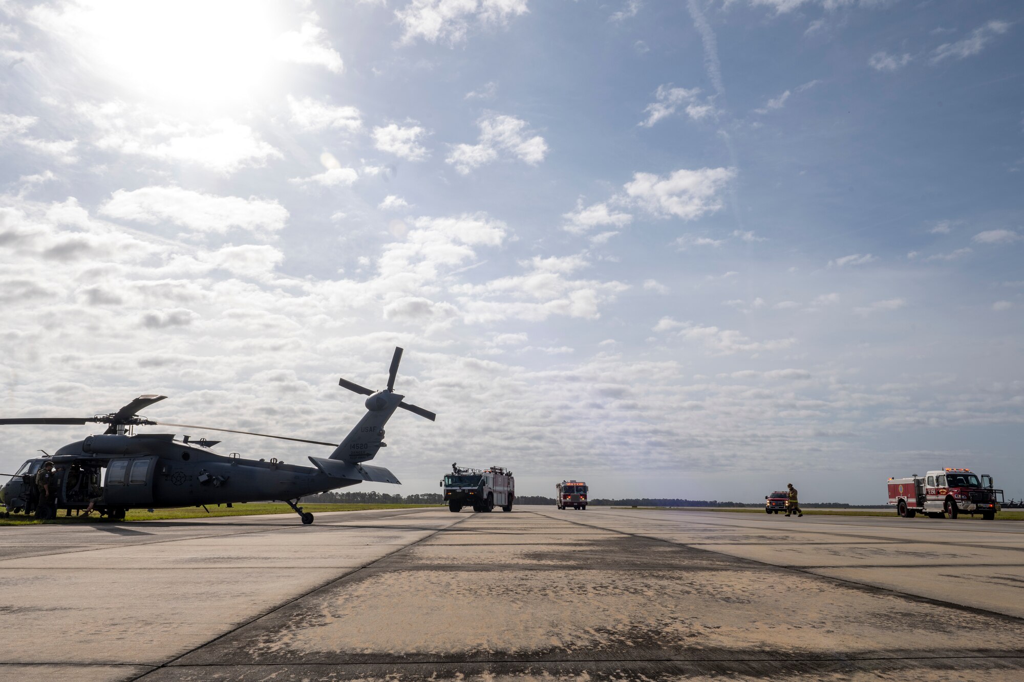 U.S. Air Force Airmen from the 23rd Civil Engineer Squadron Fire Department arrive to a simulated HH-60W Jolly Green II hard landing during an aircraft accident response exercise at Moody Air Force Base, Georgia, March 26, 2024. This home-station exercise simulated a hard landing of the aircraft with injured aircrew members designed to test Moody AFB’s communication and response functions. (U.S. Air Force photo by Senior Airman Deanna Muir)