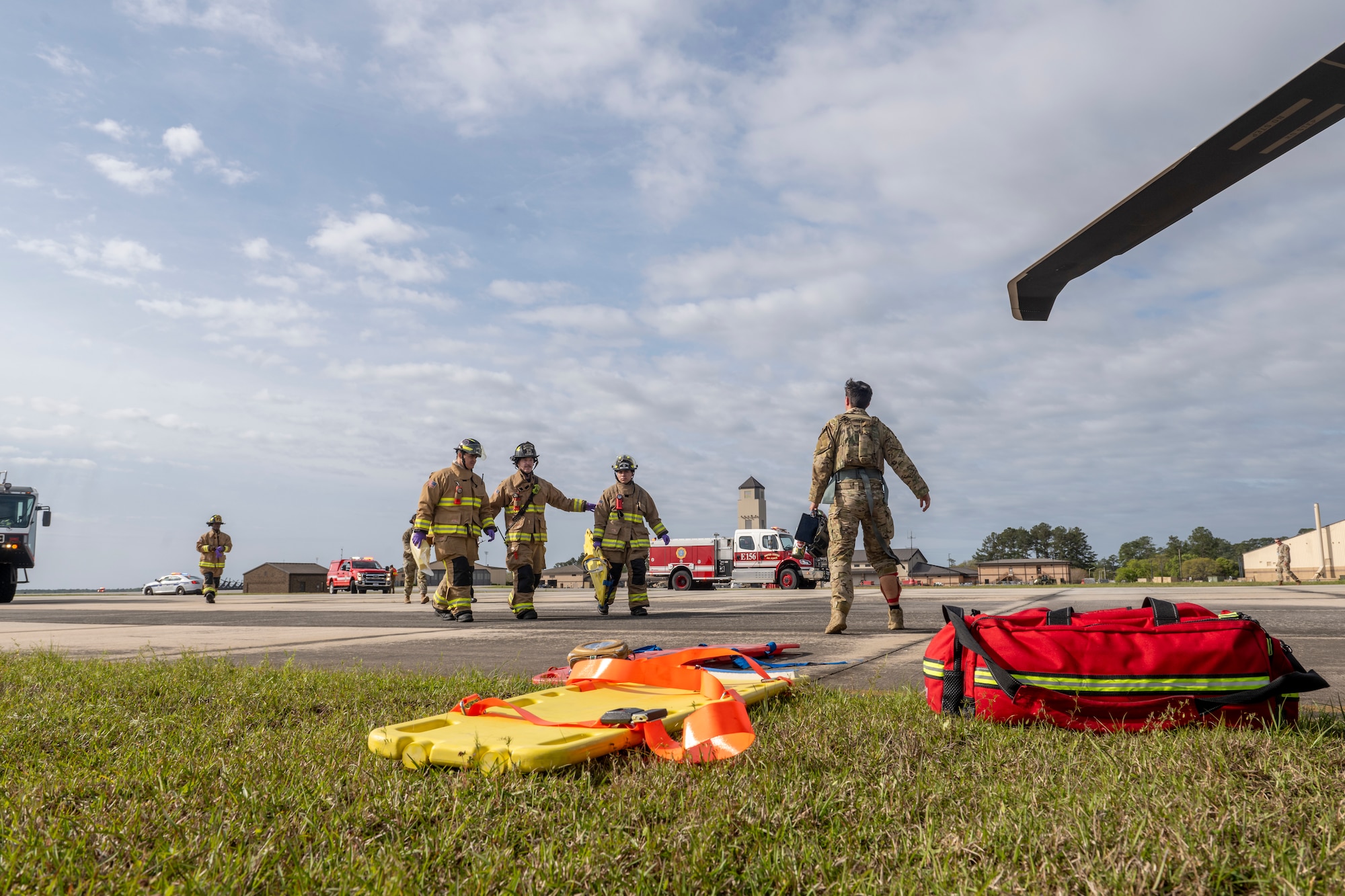 U.S. Air Force Airmen from the 23rd Civil Engineer Squadron Fire Department arrive to a simulated HH-60W Jolly Green II hard landing during an aircraft accident response exercise at Moody Air Force Base, Georgia, March 26, 2024. First responders assessed the situation and provided triage to the patients, determining their required level of treatment. (U.S. Air Force photo by Senior Airman Deanna Muir)