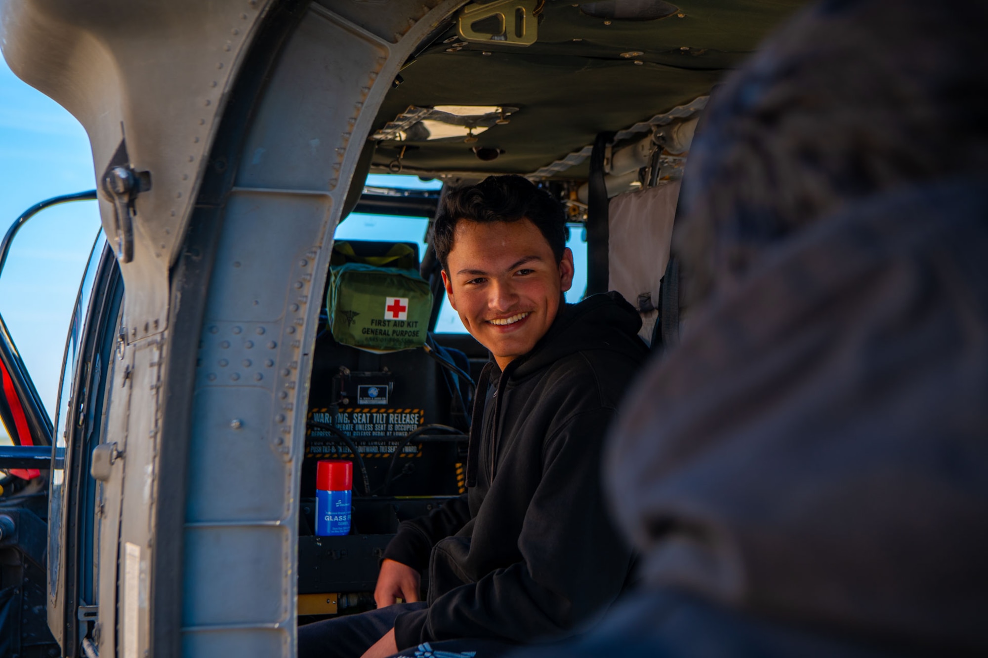 An attendee smiles as they navigate the inside of an Oklahoma National Guard UH-60M Blackhawk during the 137th Special Operations Wing 2024 Student Flight Fest Invitational event held at Will Rogers Air National Guard Base, Oklahoma, March 28, 2024. The invitational allowed for students, educators and other visitors from across the state to broaden their understanding of what the Oklahoma Air National Guard has to offer through aircraft displays, interactive stations, and discussions with Airmen and Soldiers from diverse career fields.