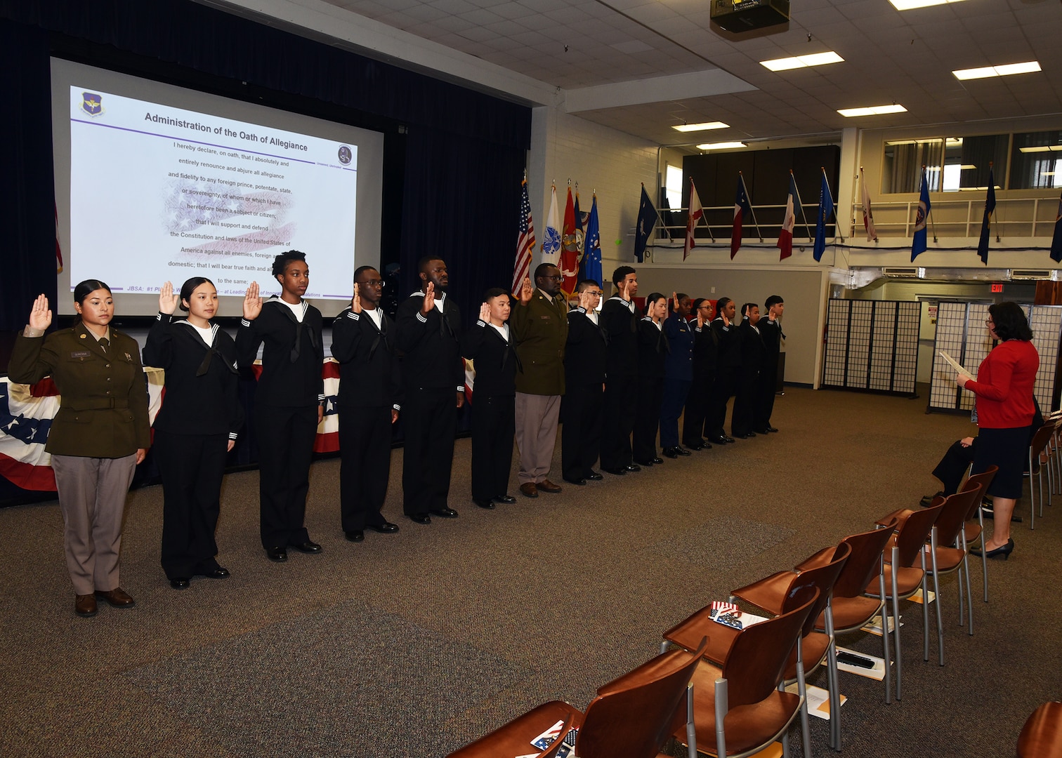 JOINT BASE SAN ANTONIO-FORT SAM HOUSTON – (March 27, 2024) – Immigration Service Officer Yoli Fleming administers the Oath of Allegiance to 15 service members from the U.S. Army, Navy, and Air Force who became U.S. citizens from the countries of China, Kenya, Jamaica, Nigeria, Vietnam, Venezuela, and The Philippines during a U.S. Citizenship Naturalization Oath Ceremony held at the Military and Family Readiness Center.  The keynote address was delivered by Navy Nurse Capt. Jennifer Buechel, of Woodhaven, Mich., commanding officer, Naval Medical Research Unit (NAMRU) San Antonio. NAMRU San Antonio’s mission is to conduct gap driven combat casualty care, craniofacial, and directed energy research to improve survival, operational readiness, and safety of Department of Defense (DoD) personnel engaged in routine and expeditionary operations. It is one of the leading research and development laboratories for the U.S. Navy under the DoD and is one of eight subordinate research commands in the global network of laboratories operating under the Naval Medical Research Command in Silver Spring, Md. (U.S. Navy photo by Burrell Parmer, NAMRU San Antonio Public Affairs/Released)