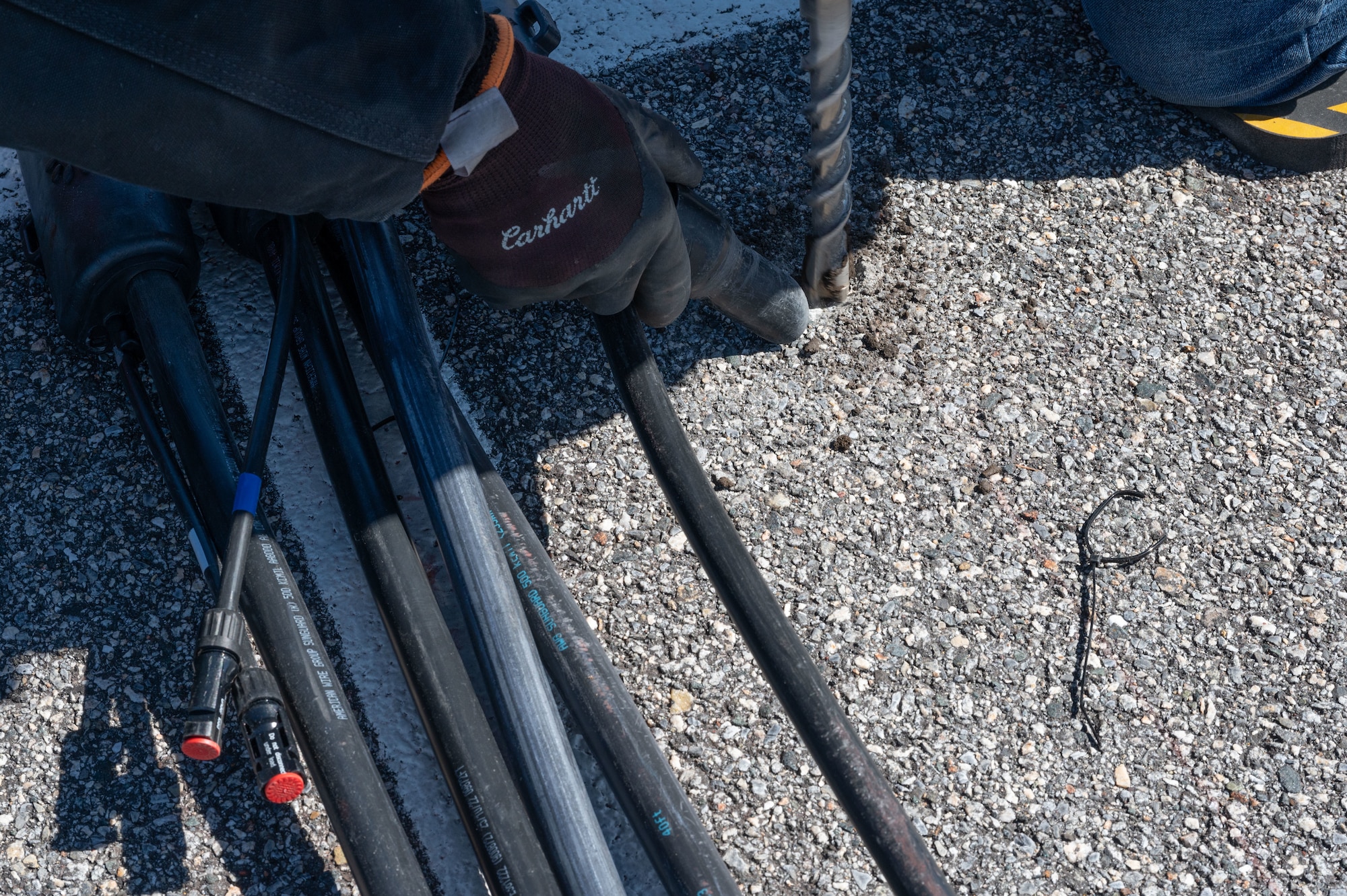 Contractors drill into asphalt during the installation of an electric vehicle charging station on Dover Air Force Base, Delaware, March 25, 2024. Team Dover’s switch to EV’s began in November 2022 and is currently in phase three of the five-phase process; it is anticipated to be completed by the end of 2024. (U.S. Air Force photo by Airman 1st Class Dieondiere Jefferies)