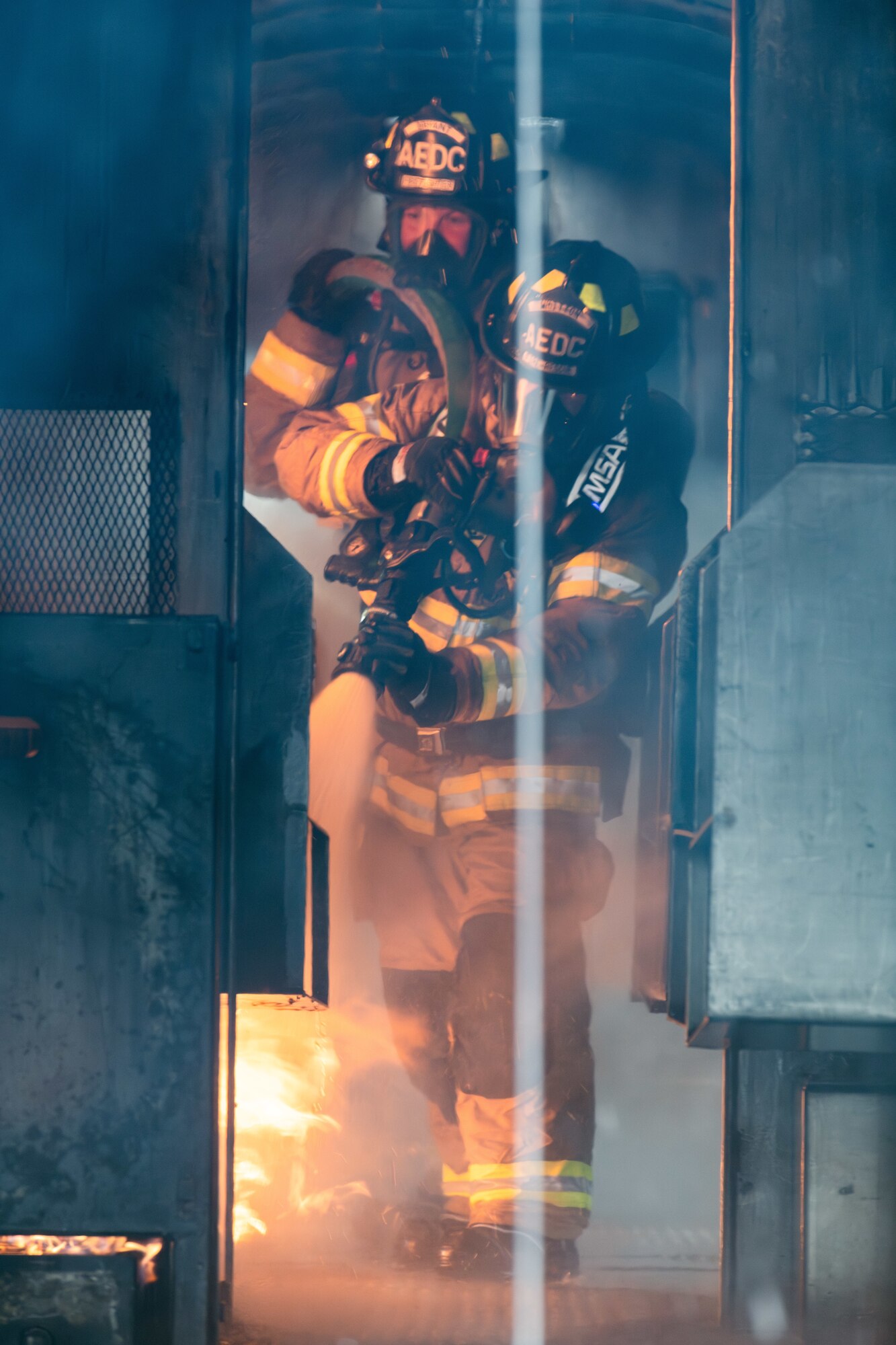 Arnold Air Force Base Fire and Emergency Services firefighters Joseph Bryant, left, and David Whitton use a handline to tackle a simulated fire in the interior of an aircraft during fuselage fire training March 5, 2024, at Arnold AFB, Tenn., headquarters of Arnold Engineering Development Complex. Arnold FES crews took part in live structural fire training Feb. 27-29, 2024, and live aircraft fire training March 5-7, 2024. (U.S. Air Force photo by Keith Thornburgh)